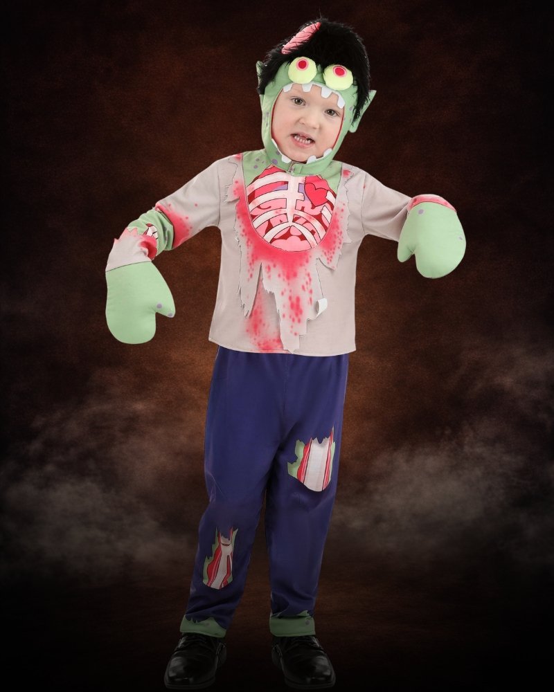 Toddler wearing a goofy zombie Halloween costume with monster hood, cartoon details, and green zombie hands