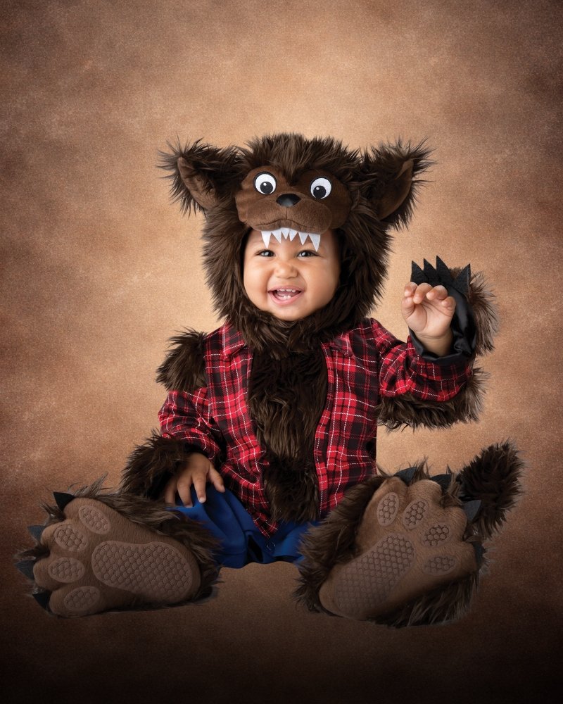 Baby wearing a premium werewolf Halloween costume with furry hood, flannel shirt, and soft paw details