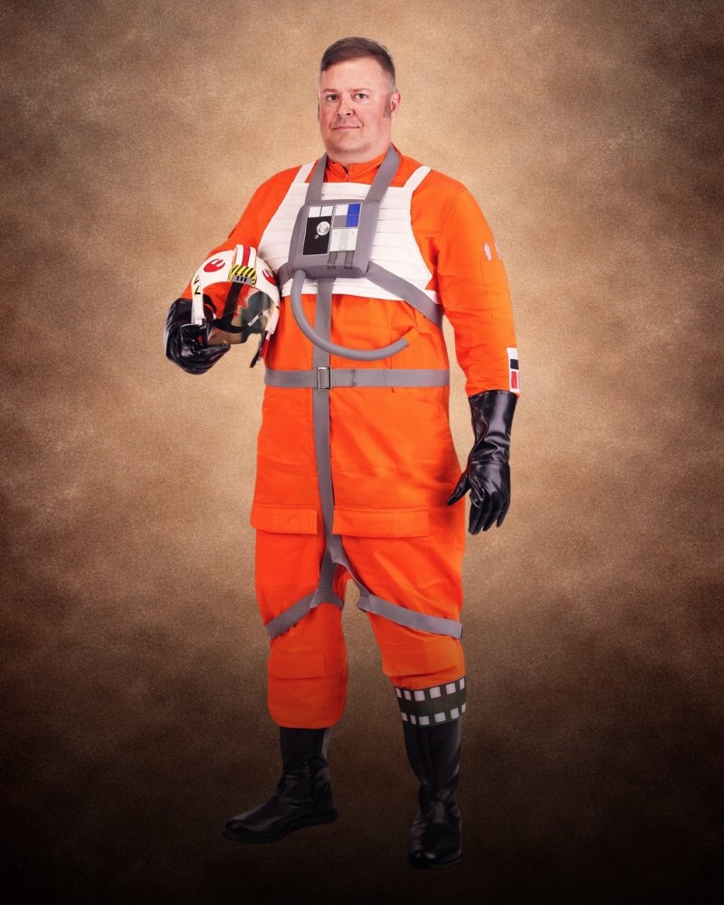 Plus Size Deluxe Star Wars X-Wing Pilot Costume for Men with orange flight suit, white pilot vest, chest box, straps, and Rebel helmet