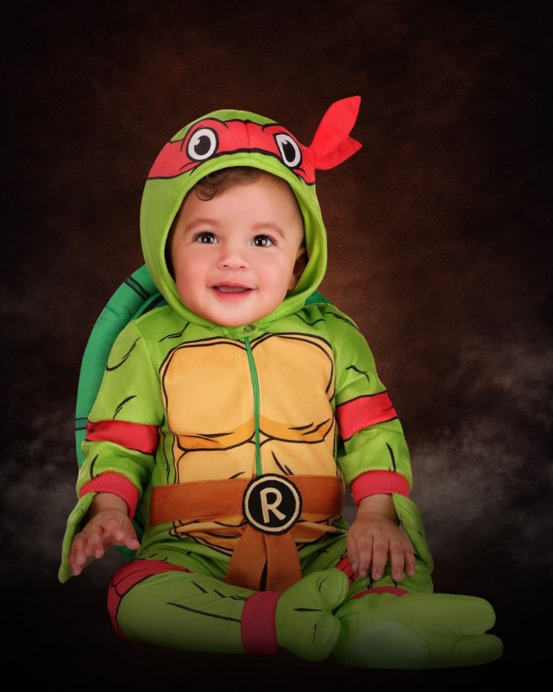 Teenage Mutant Ninja Turtles Infant Raphael costume with green turtle onesie, red bandana hood, shell, and matching booties