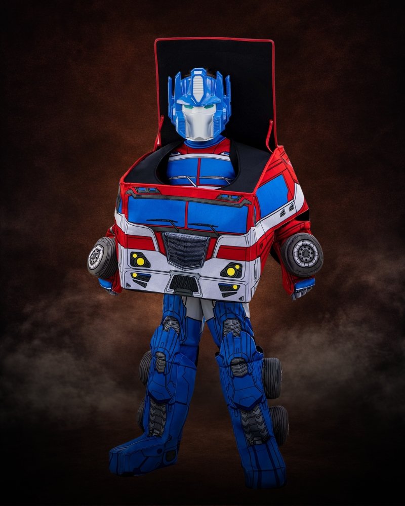 Transformers Optimus Prime costume for boys featuring red and blue robot jumpsuit, truck cab body piece, mask, gloves, and boot covers.