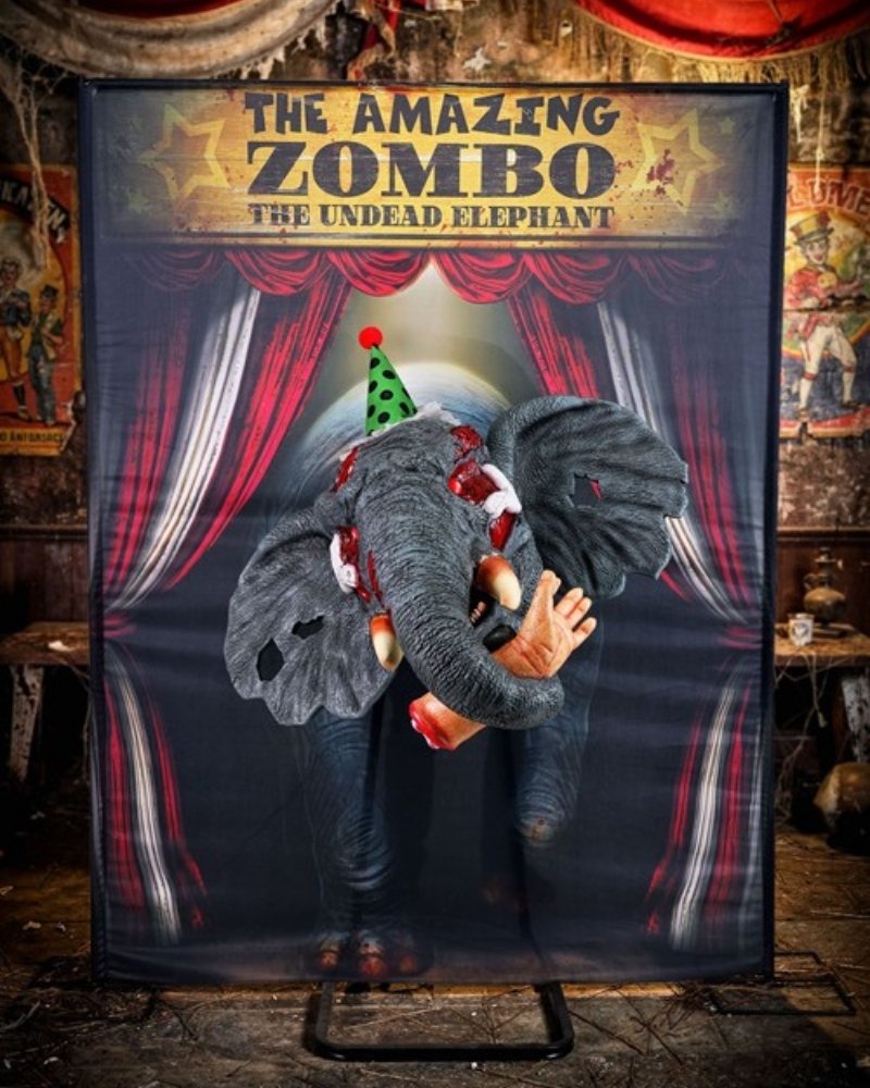 Zombo undead elephant Halloween Actor-matronic with weathered gray skin, glowing red eyes, tusks and green polka-dot party hat